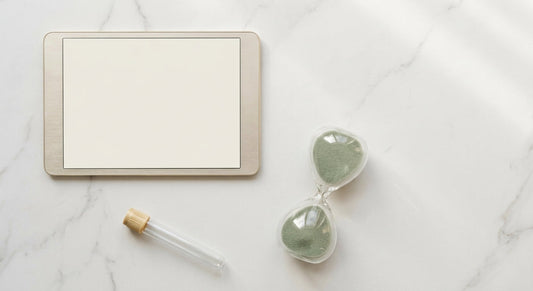 A minimalist flat lay of a digital calendar, hourglass, and specimen tube on a white marble surface, symbolizing timed health testing windows.